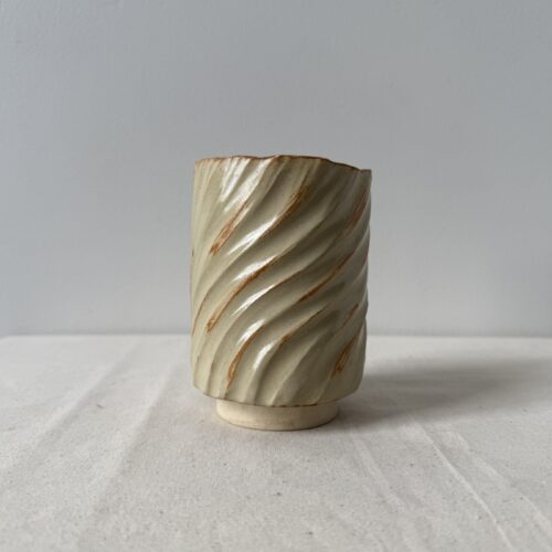 ceramic japanese teacup in wavy rust wash on neutral linen fabric and cream wall background by studio hon handbuilding pottery